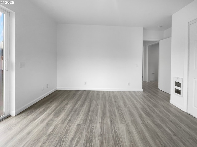 spare room featuring heating unit and light hardwood / wood-style floors