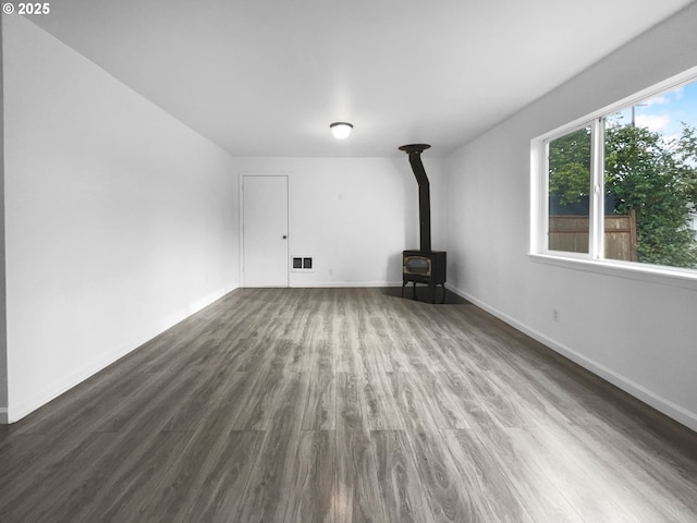 unfurnished living room featuring hardwood / wood-style flooring and a wood stove