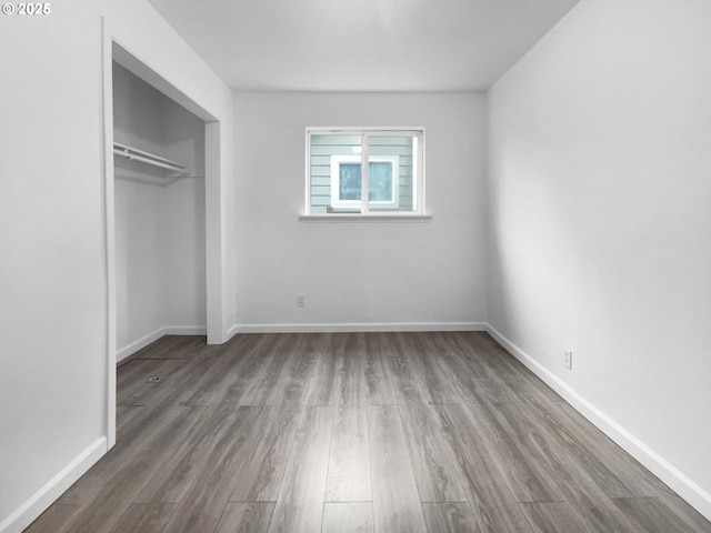 unfurnished bedroom featuring a closet and hardwood / wood-style flooring