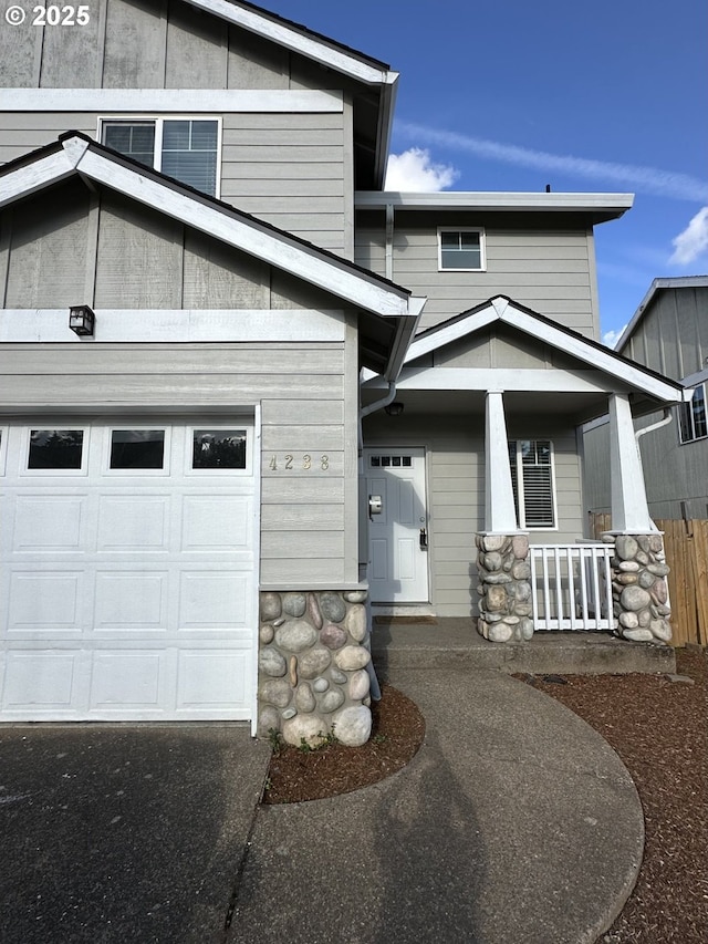 4238 SE 120th Ave, Portland, OR 97266 - view of front facade featuring a porch, stone siding, and a garage