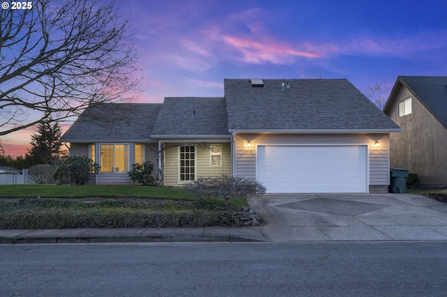 view of front facade with a front lawn, an attached garage, driveway, and a shingled roof