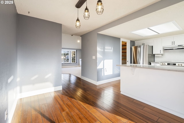 5219 Spring Leaf Ct N, Keizer, OR 97303 - kitchen with freestanding refrigerator, under cabinet range hood, light countertops, wood-type flooring, and white cabinets