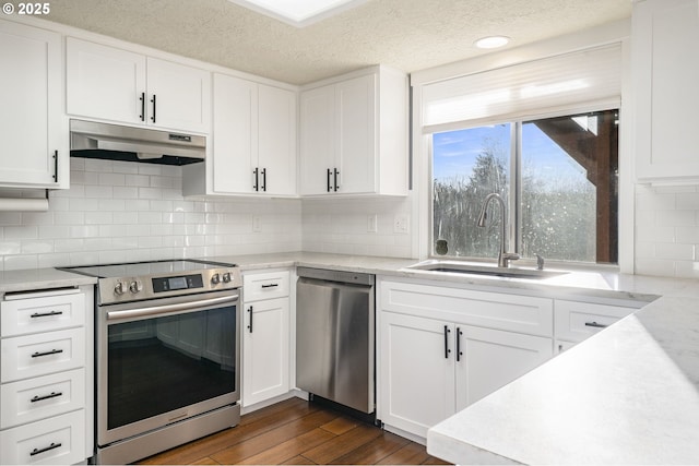 5219 Spring Leaf Ct N, Keizer, OR 97303 - kitchen featuring stainless steel appliances, under cabinet range hood, dark wood-type flooring, white cabinets, and backsplash