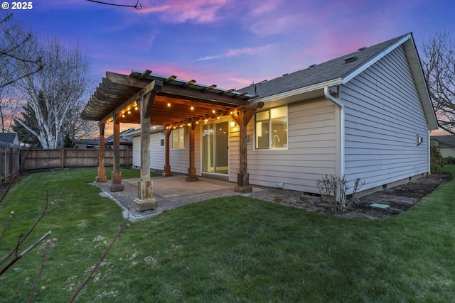 back of property at dusk featuring a patio area, fence, and a lawn