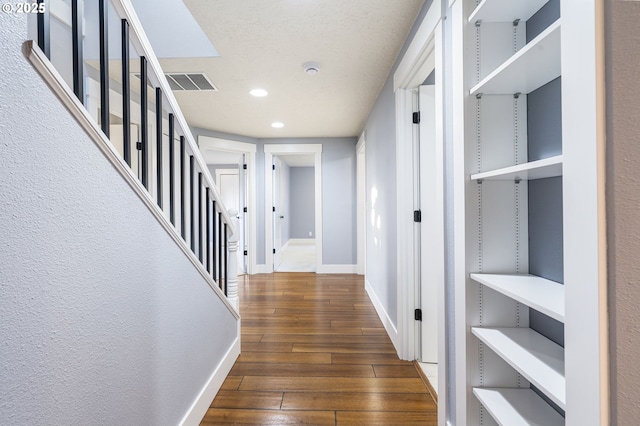 hall featuring stairway, baseboards, visible vents, recessed lighting, and dark wood-style flooring