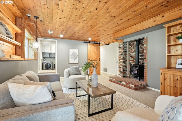 20681 S Wisteria Rd, West Linn, OR 97068 - living room with washer and dryer, carpet, a wood stove, recessed lighting, and a barn door