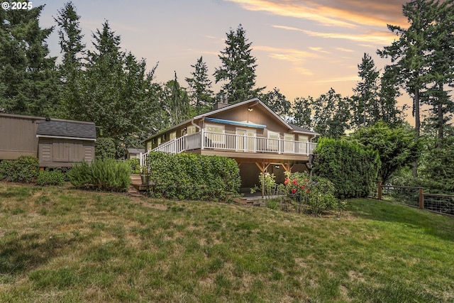 20681 S Wisteria Rd, West Linn, OR 97068 - back of house at dusk with a deck, a chimney, and a storage unit