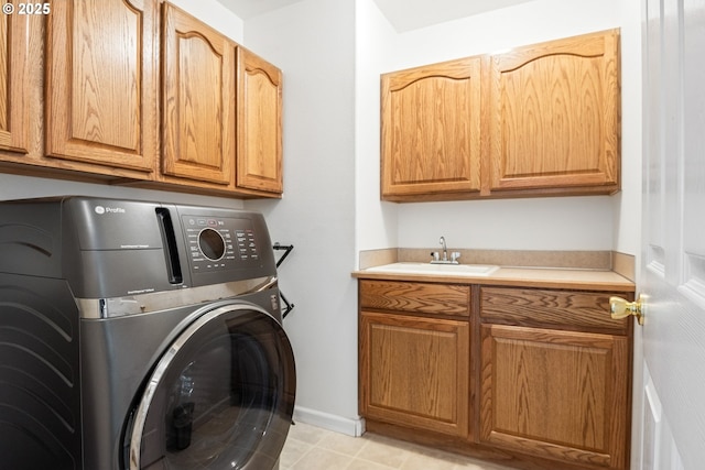 laundry area featuring washing machine and dryer, sink, and cabinets