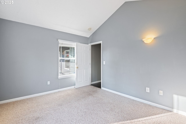 spare room featuring lofted ceiling and carpet flooring