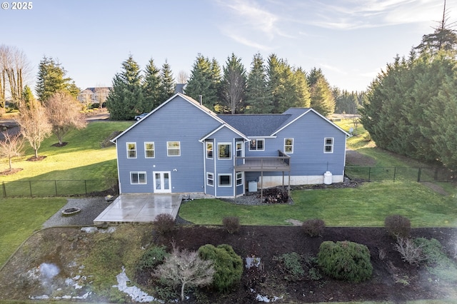 rear view of property with a patio area, a wooden deck, french doors, and a lawn