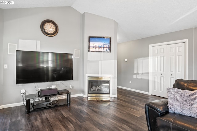 living room featuring lofted ceiling, dark hardwood / wood-style flooring, and a textured ceiling