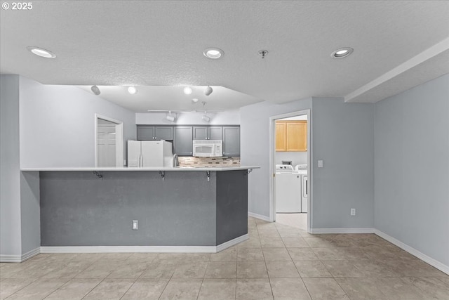 15420 NE Knott St Unit 2, Portland, OR 97230 - kitchen with white appliances, washing machine and clothes dryer, decorative backsplash, recessed lighting, and baseboards