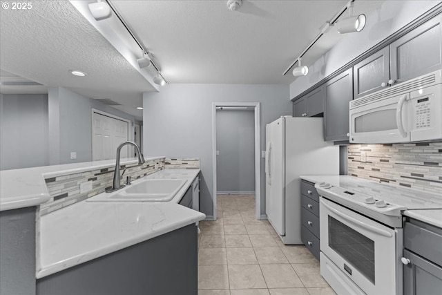 15420 NE Knott St Unit 2, Portland, OR 97230 - kitchen with white appliances, track lighting, backsplash, a sink, and light tile patterned floors
