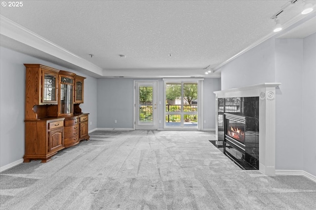 15420 NE Knott St Unit 2, Portland, OR 97230 - unfurnished living room featuring a textured ceiling, light carpet, rail lighting, a fireplace, and baseboards