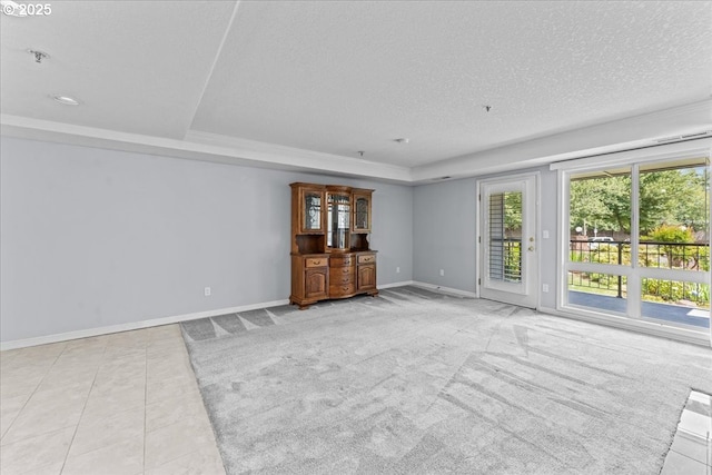 15420 NE Knott St Unit 2, Portland, OR 97230 - unfurnished living room with baseboards, a textured ceiling, a raised ceiling, and light tile patterned floors