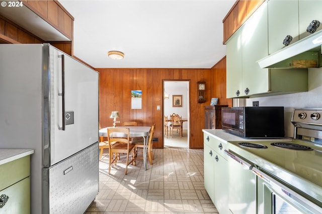 6455 SW Scholls Ferry Rd, Portland, OR 97223 - kitchen with freestanding refrigerator, white electric range oven, black microwave, wood walls, and light countertops