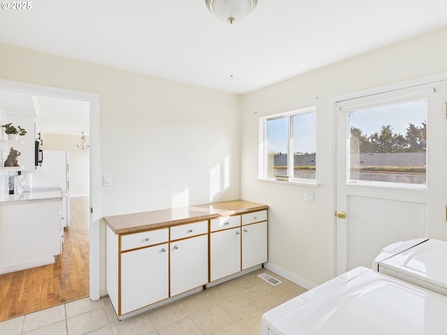 415 NE 99th St, Vancouver, WA 98665 - laundry area with washing machine and clothes dryer, light tile patterned floors, a chandelier, and cabinet space