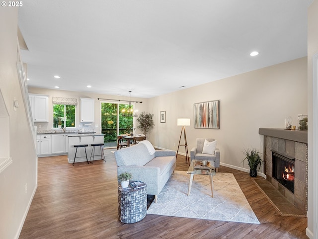 13143 SW Brianne Way, Portland, OR 97223 - living area featuring wood finished floors, a tiled fireplace, and recessed lighting
