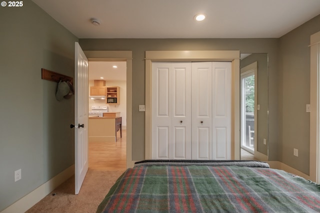 bedroom featuring recessed lighting, a closet, light carpet, and baseboards
