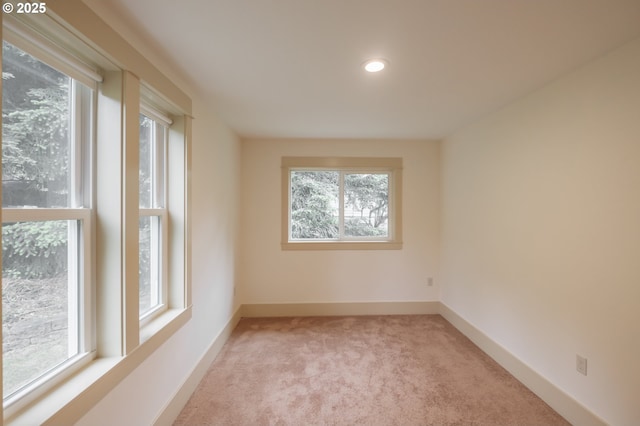 spare room with light carpet, recessed lighting, and baseboards