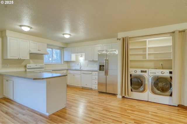 kitchen with white cabinets, range, dishwasher, washing machine and clothes dryer, and stainless steel fridge