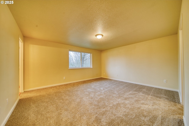 empty room featuring a textured ceiling and carpet