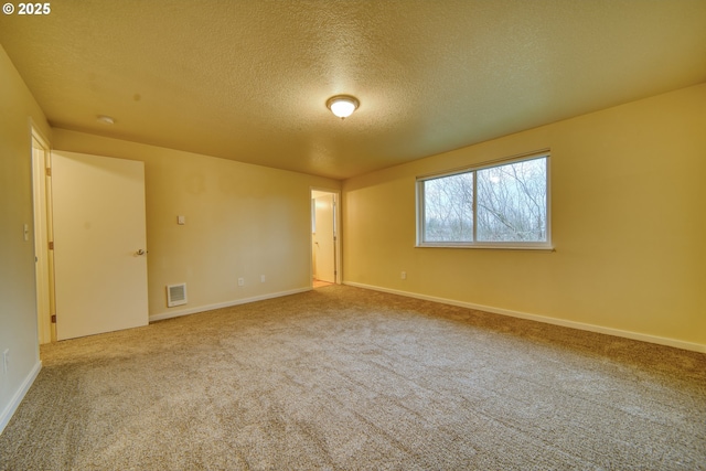 carpeted spare room with a textured ceiling