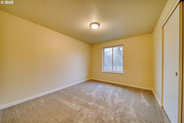 unfurnished room featuring a textured ceiling and carpet flooring