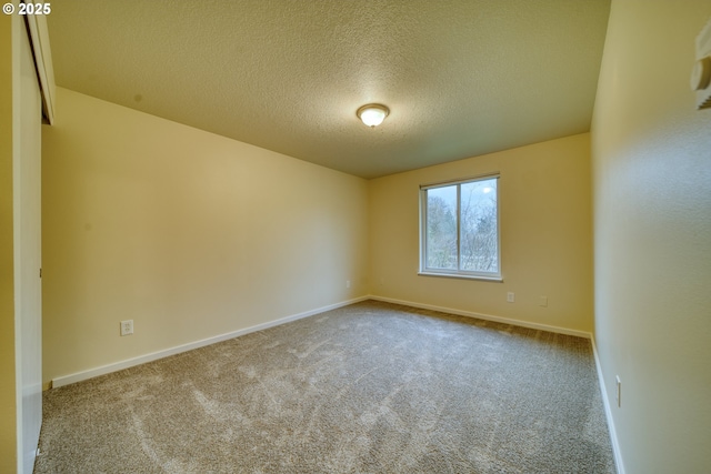 carpeted spare room featuring a textured ceiling