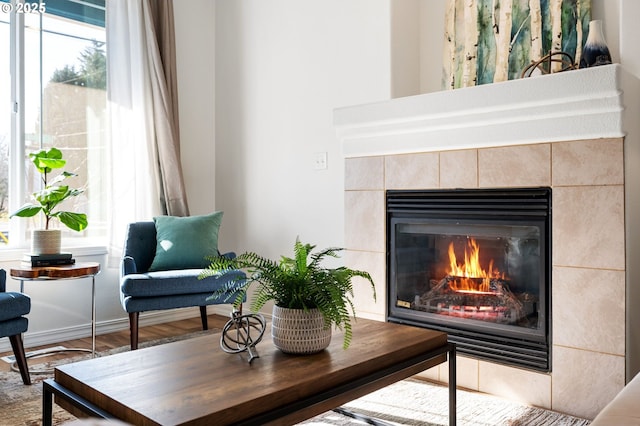 sitting room featuring a tiled fireplace and hardwood / wood-style flooring