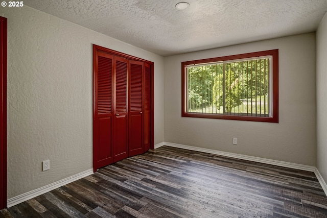 16170 Mcbee Rd, Dallas, OR 97338 - unfurnished bedroom featuring dark wood-style floors, a closet, a textured ceiling, baseboards, and a textured wall