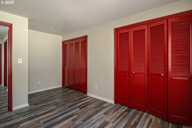 16170 Mcbee Rd, Dallas, OR 97338 - unfurnished bedroom featuring dark wood-style floors, a textured ceiling, two closets, and baseboards