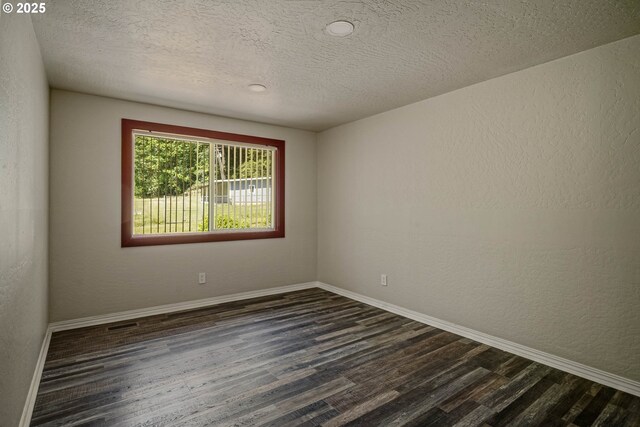 16170 Mcbee Rd, Dallas, OR 97338 - empty room featuring dark wood-style floors, baseboards, a textured ceiling, and a textured wall