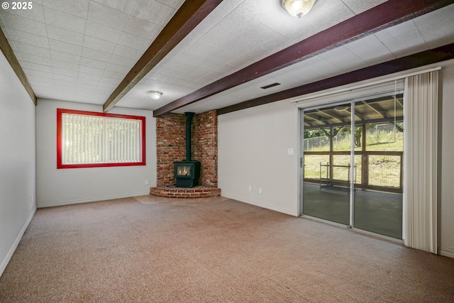 16170 Mcbee Rd, Dallas, OR 97338 - unfurnished living room featuring a wood stove, beamed ceiling, carpet, and baseboards