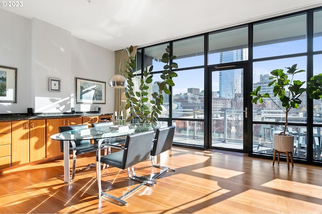 dining room with a wall of windows and light wood-type flooring