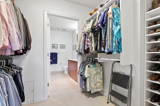 spacious closet featuring heating unit and light colored carpet