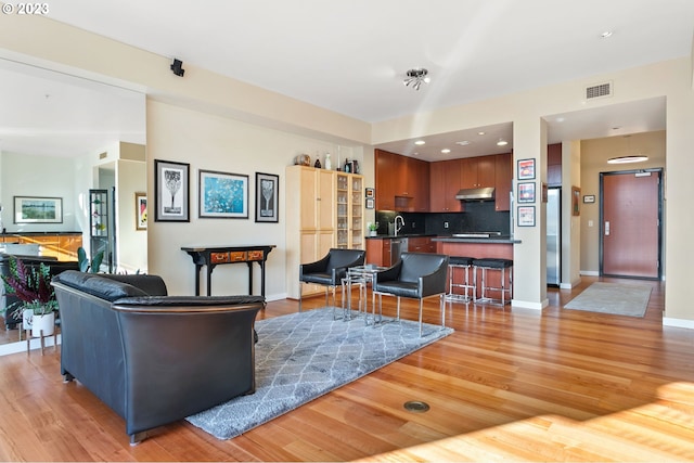 living room with sink and light hardwood / wood-style floors