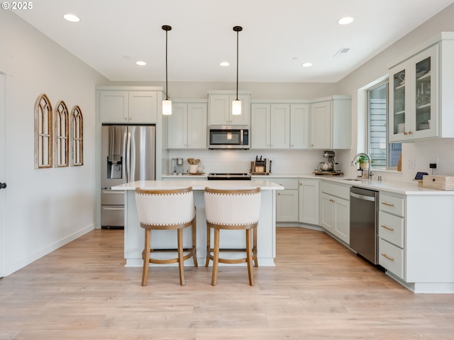 kitchen featuring a kitchen island, appliances with stainless steel finishes, and white cabinets