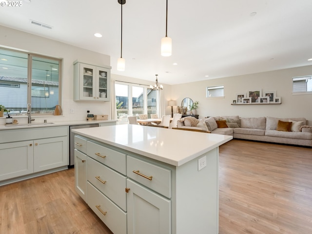 kitchen with sink, decorative light fixtures, plenty of natural light, and a kitchen island