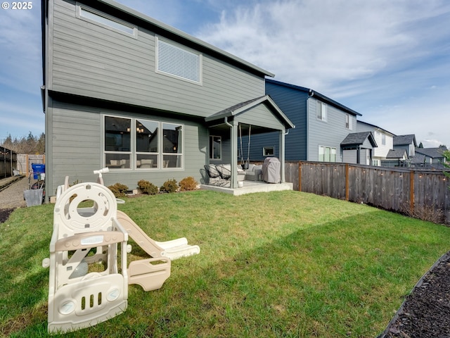 rear view of house with a patio area and a lawn