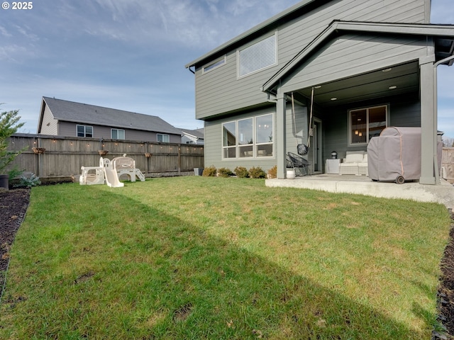 rear view of house featuring a yard and a patio area