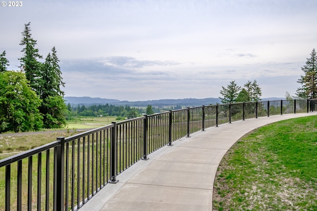 surrounding community with a mountain view and a yard