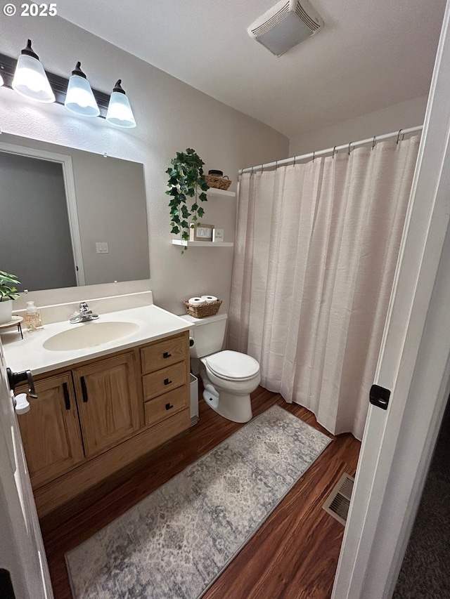 bathroom featuring hardwood / wood-style flooring, vanity, and toilet