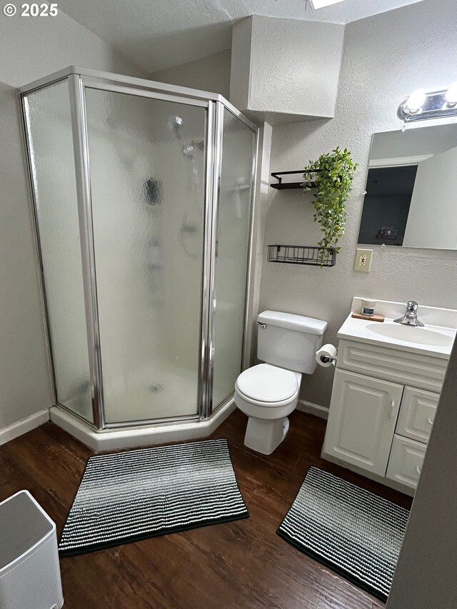 bathroom with vanity, toilet, an enclosed shower, and wood-type flooring