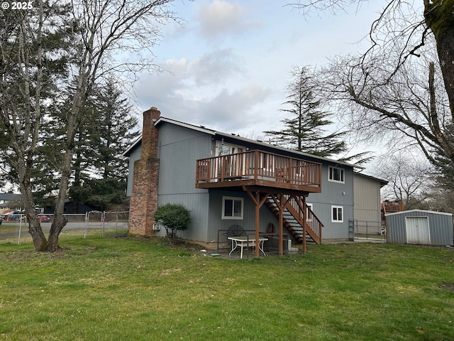 back of property with a wooden deck, a shed, and a lawn