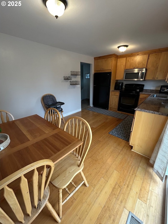 kitchen featuring light hardwood / wood-style floors, sink, and black appliances