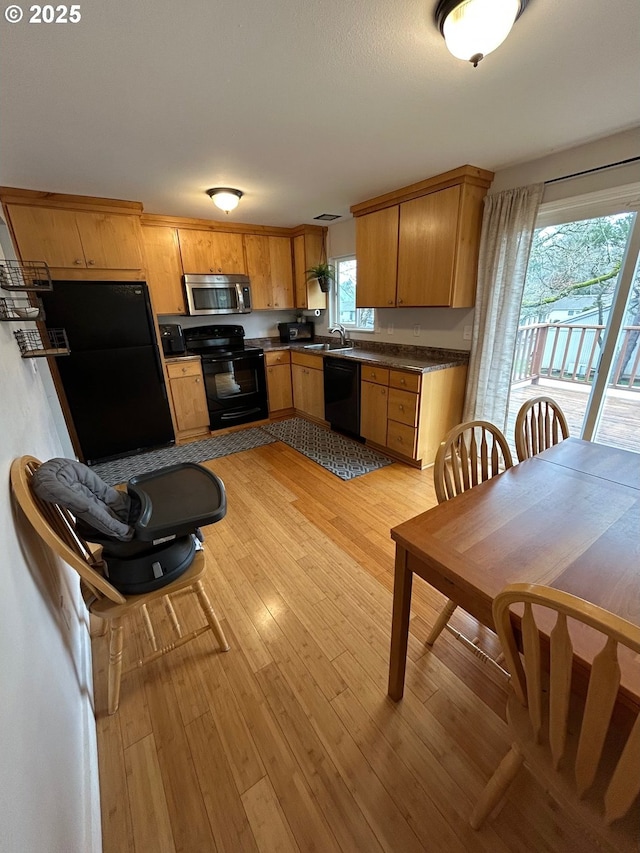 kitchen featuring sink, light wood-type flooring, and black appliances