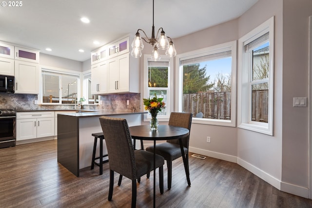 dining room with baseboards, visible vents, recessed lighting, dark wood-style flooring, and a chandelier