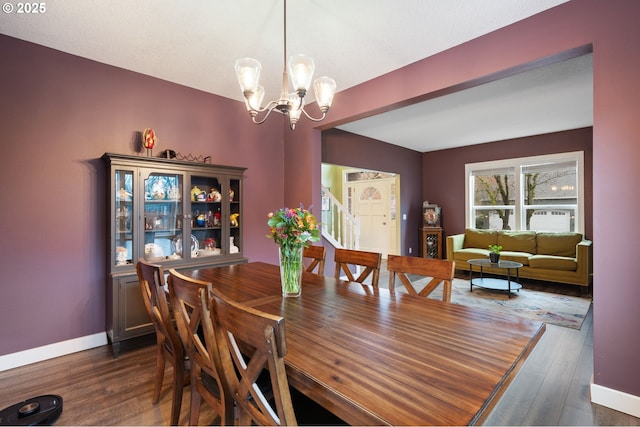 dining room featuring stairway, baseboards, an inviting chandelier, and dark wood-style flooring