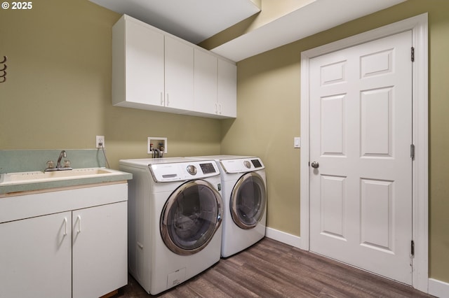 laundry area featuring independent washer and dryer, a sink, cabinet space, baseboards, and dark wood-style flooring